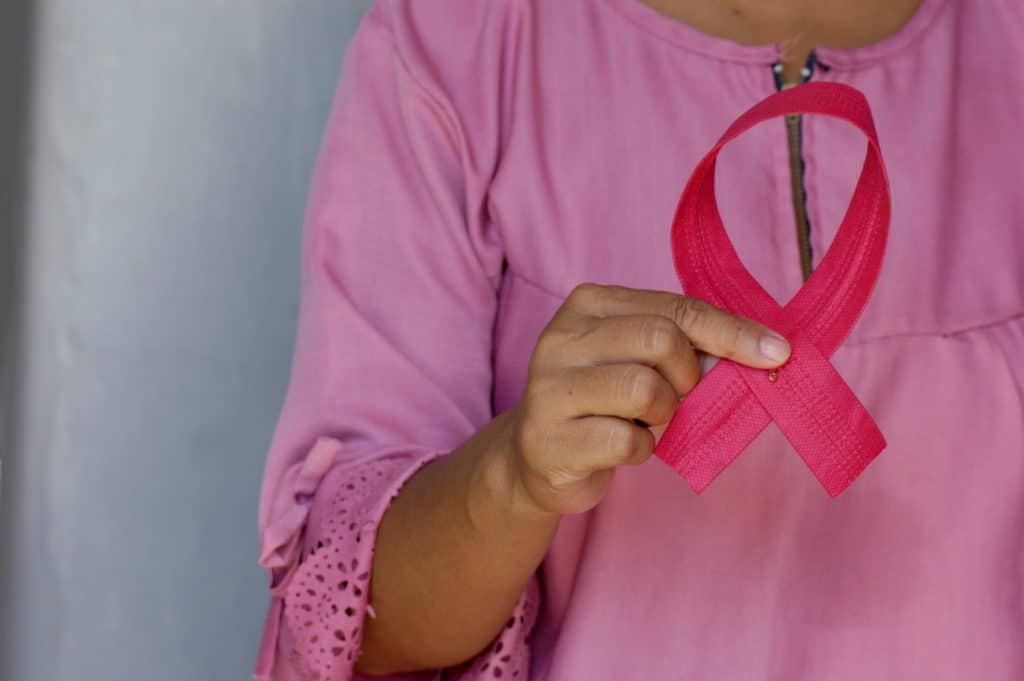 žena drži trakicu koja simbolizira borbu protiv raka dojki