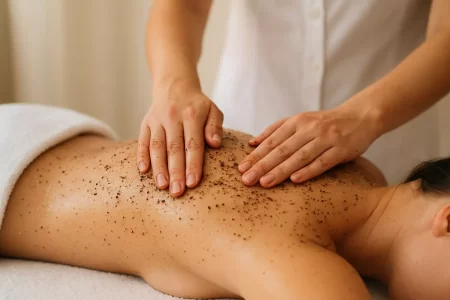 Žena leži na stolu dok joj stručnjak radi mehanički piling tijela.