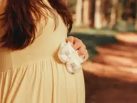 Trudnica drži bijele dječje cipelice uz trbuh, ilustracija članka o sigurnosti paracetamola u trudnoći prema studiji objavljenoj u The Lancet Obstetrics, Gynecology & Women’s Health.